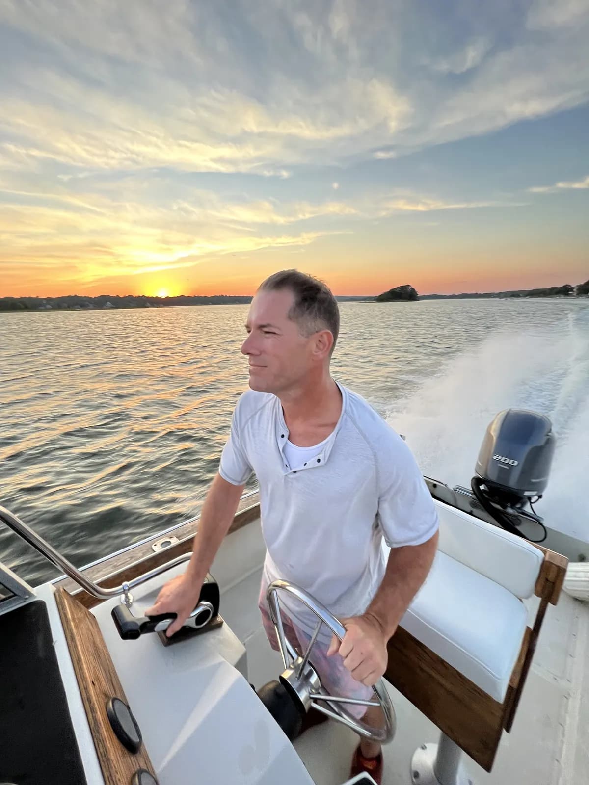 J.F. Long at the helm, Westport Harbor at sunset