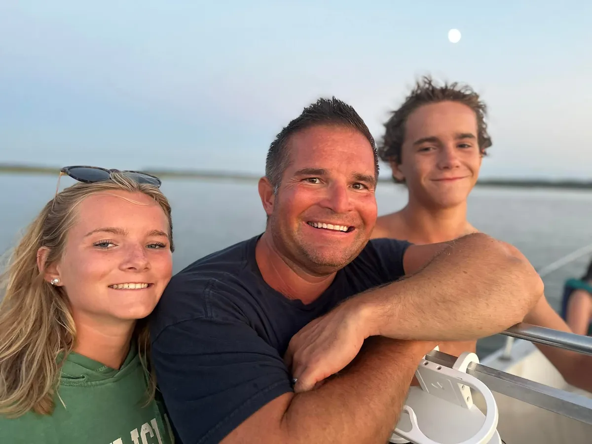 Father and children on the boat at moonrise